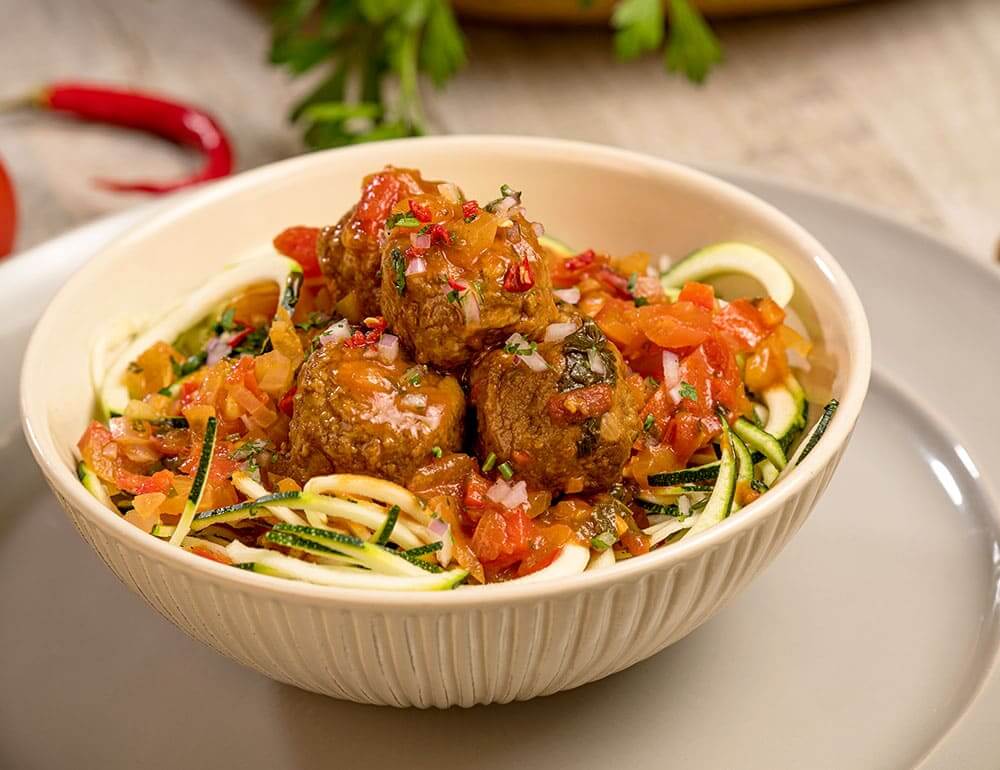 Almôndegas vegetarianas à bolonhesa em cama de curgete espiralizada