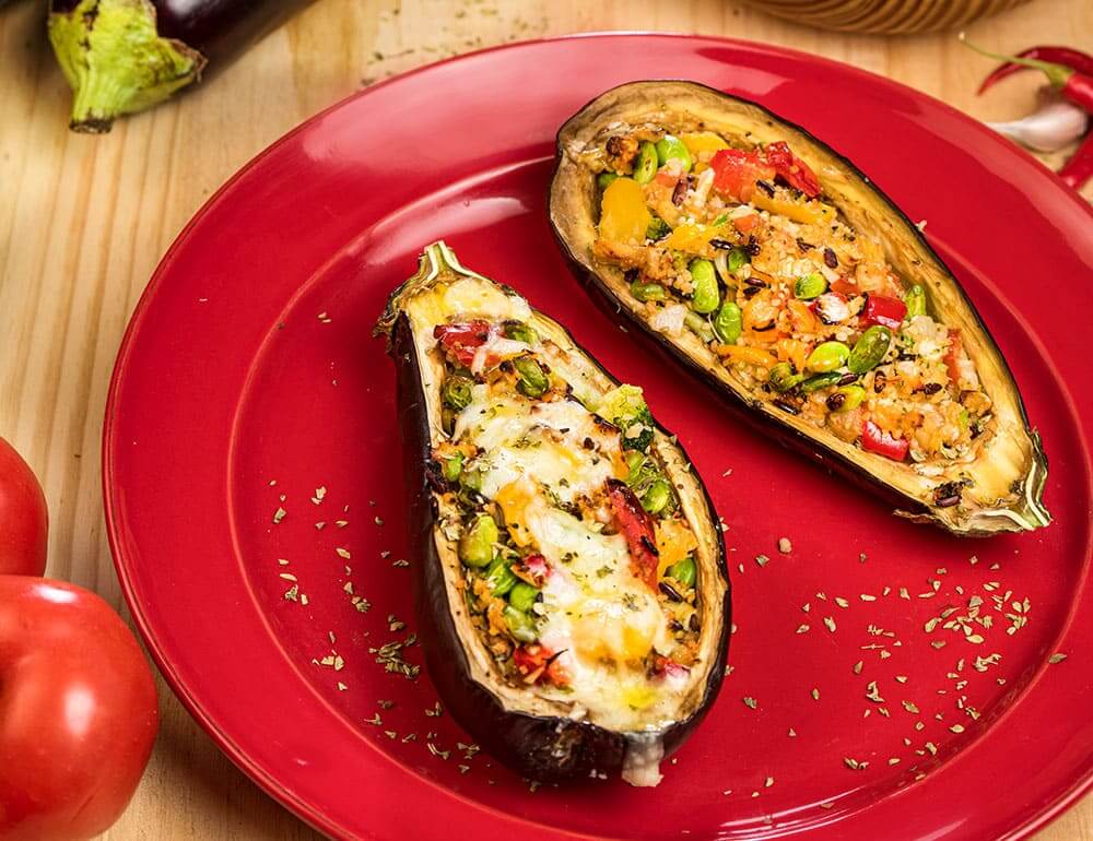 Beringela recheada com couscous, edamame e bambu com salada de tomate e orégãos